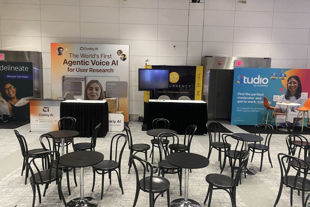 Black café tables and bistro chairs arranged for dining and networking in an event hall