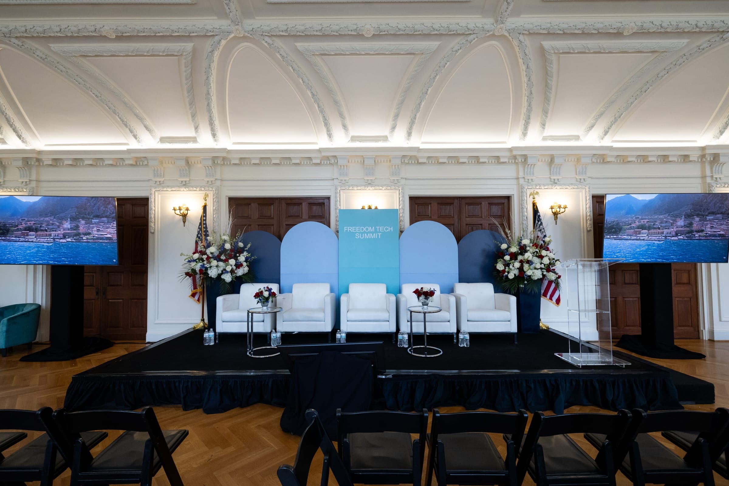 Freedom Tech Summit stage with custom arched scenic backdrop, white lounge chairs, and florals at DAR O'Byrne Gallery Freedom Tech Summit stage with custom arched scenic backdrop, white lounge chairs, and florals at DAR O'Byrne Gallery